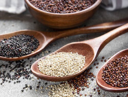 Bodegón con cucharones de quinoa blanca, roja y negra.