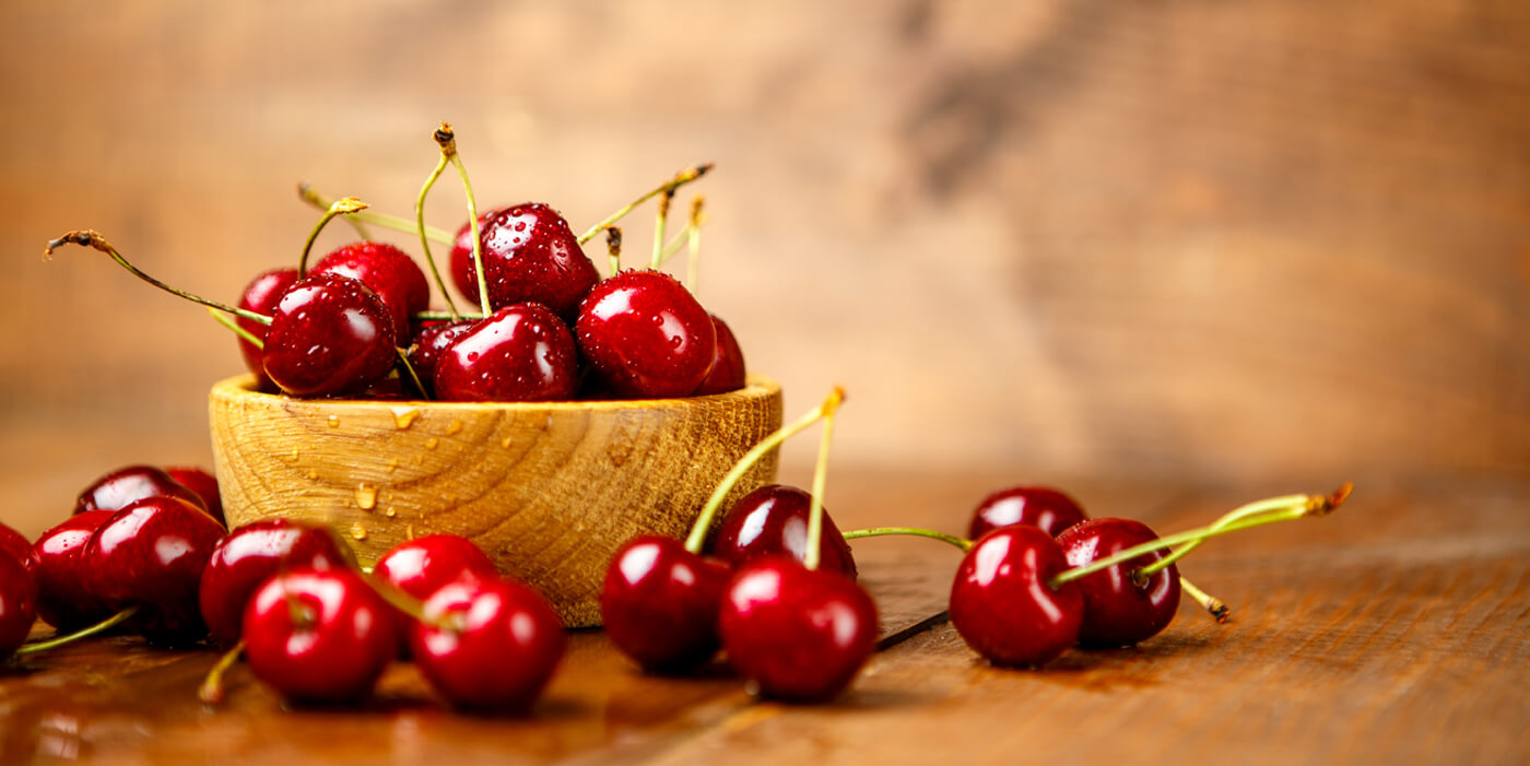 primer plano de mesa con un cuenco de cerezas