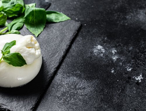 burrata y albahaca sobre tabla de pizarra