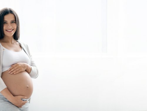 Mujer embarazada sonriente, mostrando su barriga