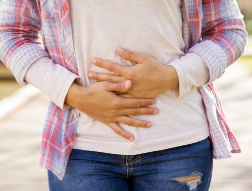 mujer apretándose el abdomen mostrando dolor