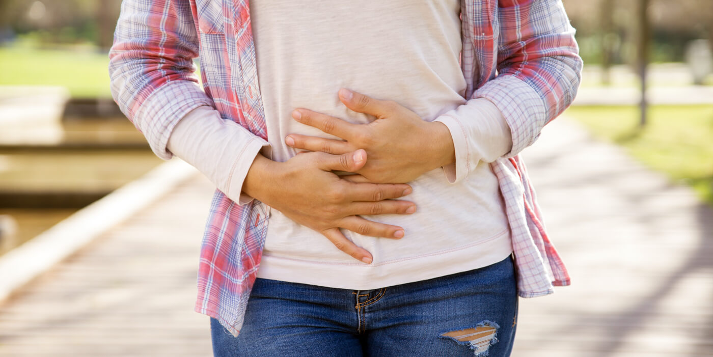 mujer apretándose el abdomen mostrando dolor